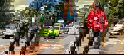 Young people walking down the street together, next to a bus lane