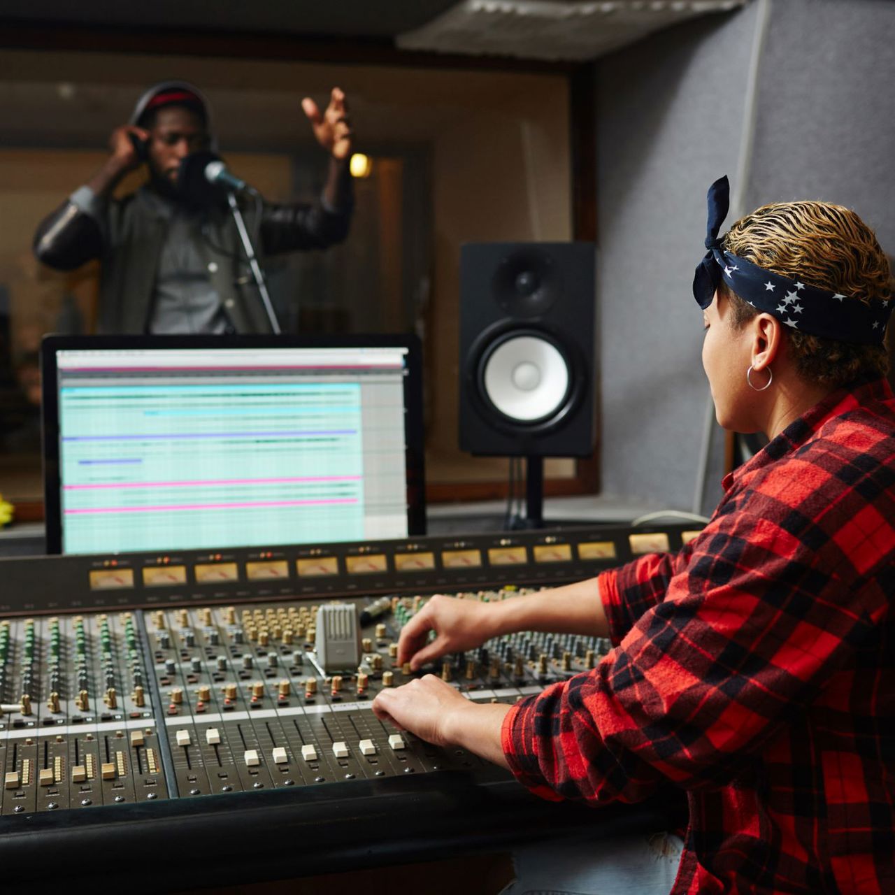 Sound operator processing music of a another musician in a recording studio