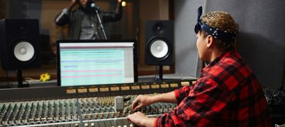 Sound operator processing music of a another musician in a recording studio