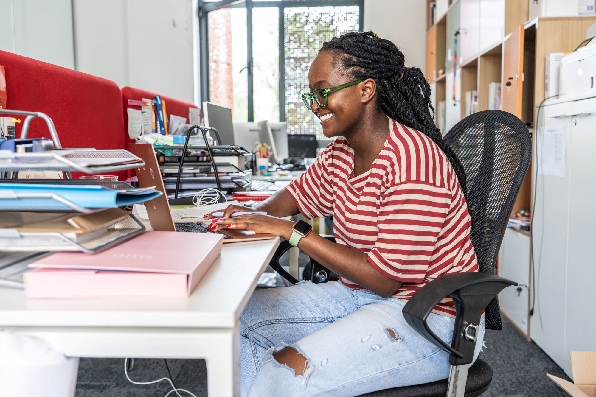 A Black Female Office Worker At Her Laptop
