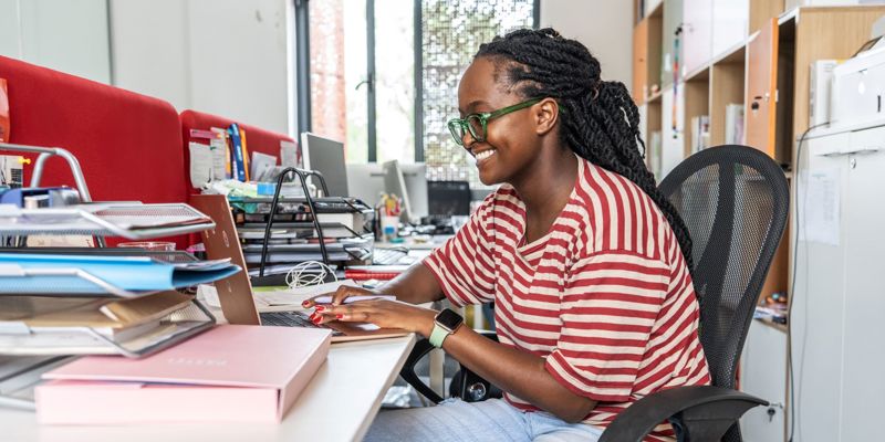 A Black Female Office Worker At Her Laptop