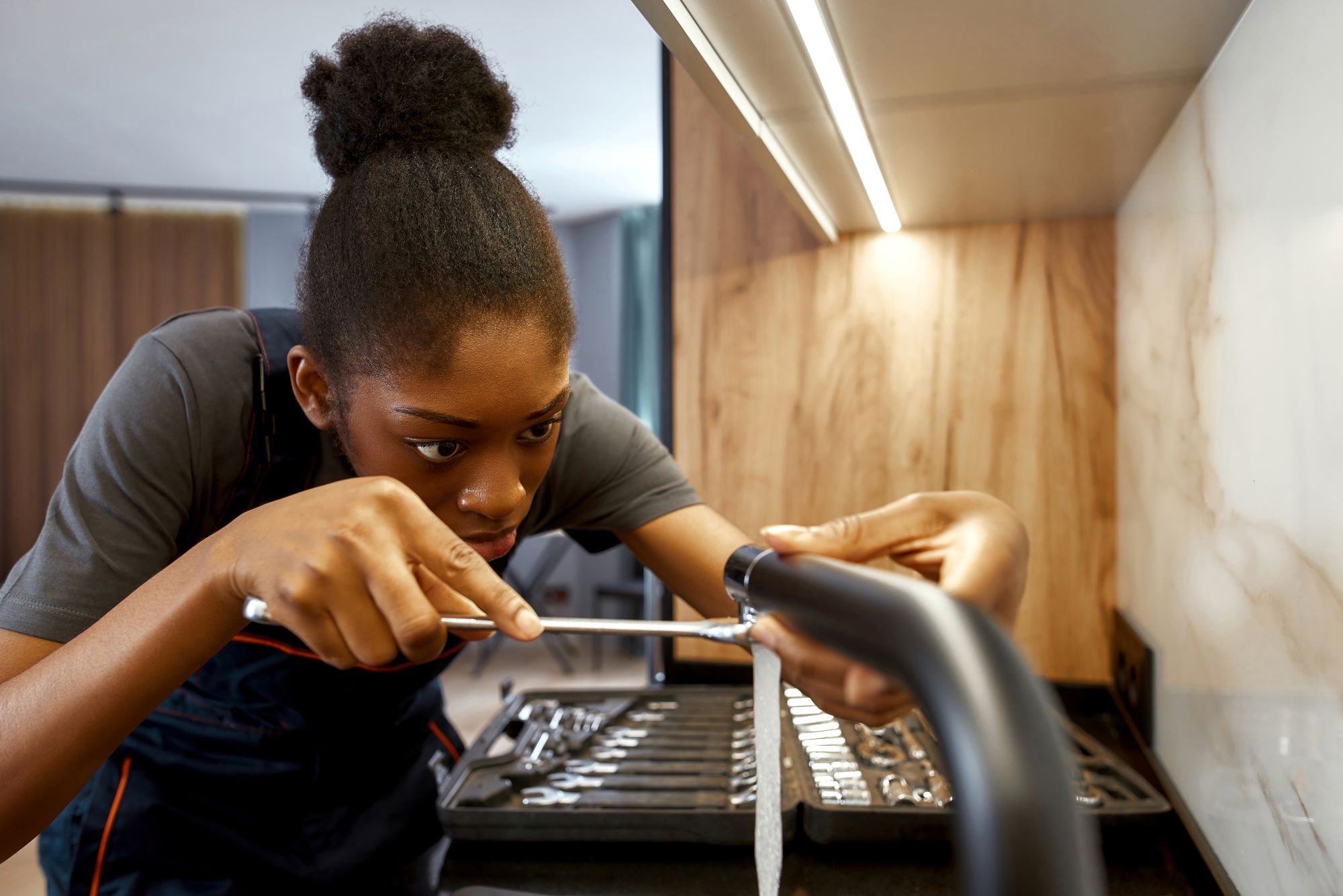 Young female plumber working on a tap