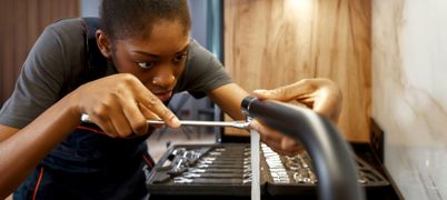 Young female plumber working on a tap