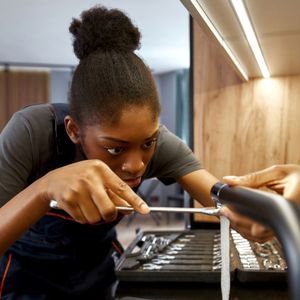 Young female plumber working on a tap