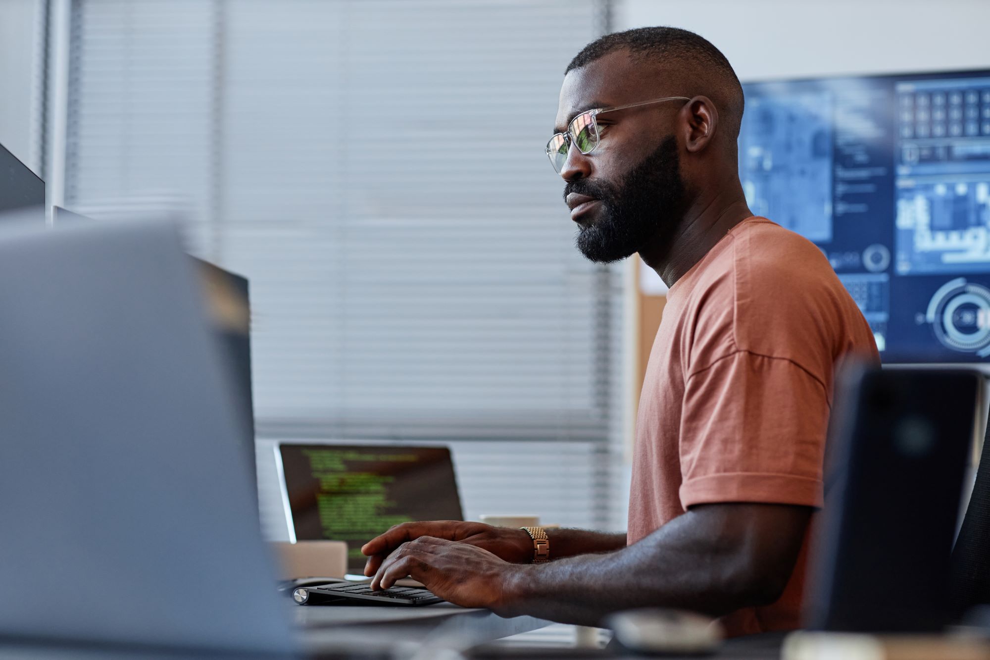 Male software developer sat at computers