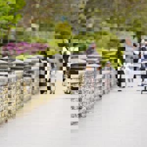 Women and children walking down the street, pushing a pram