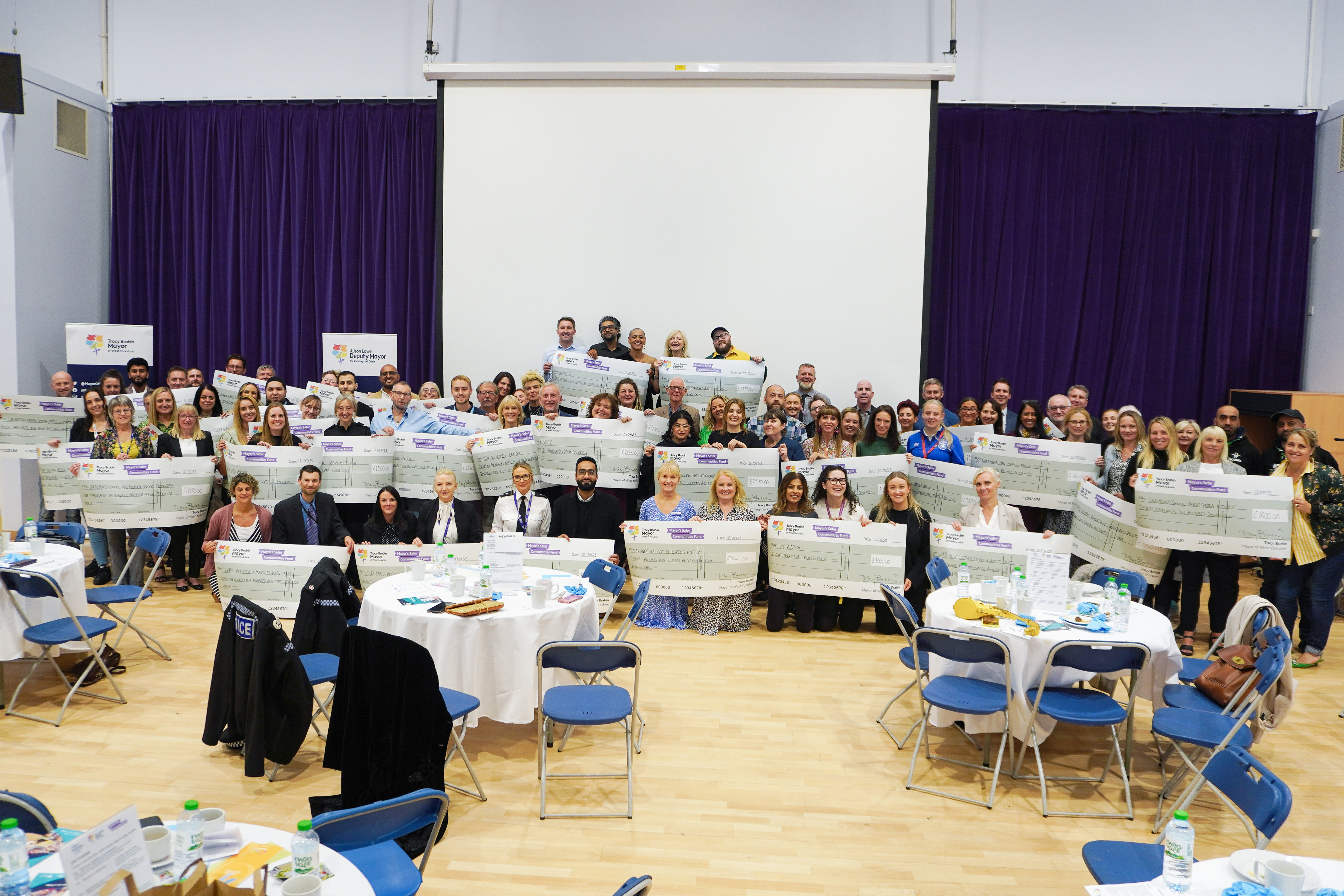 Group photo from the awards, people are holding large cheques, smiling at the camera.