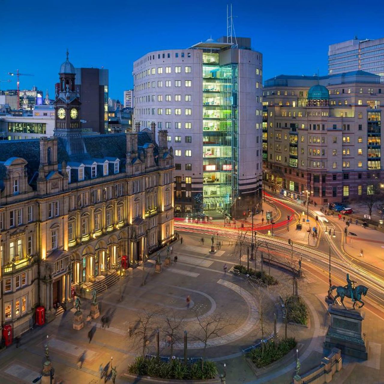 A photo of Leeds City Square at dusk