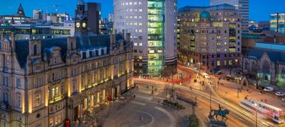 A photo of Leeds City Square at dusk