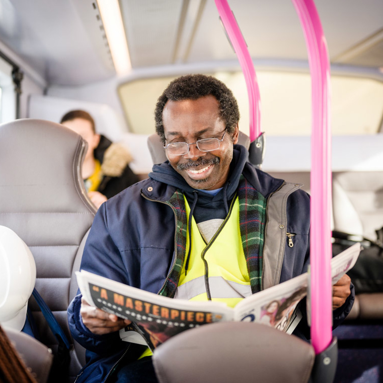 Man on bus reading newspaper