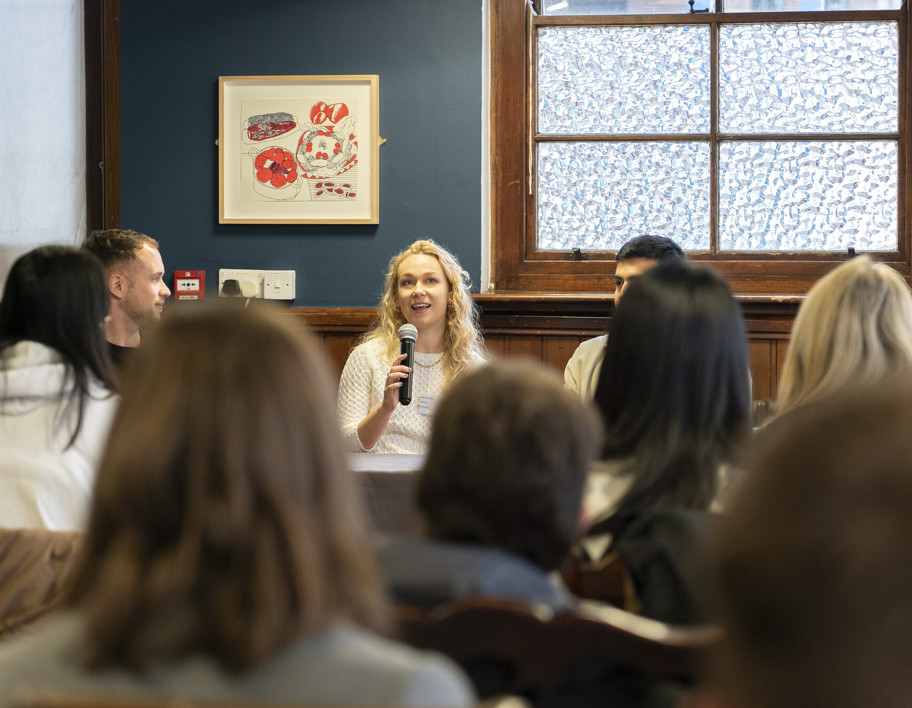 Speaker at graduate event as people listen