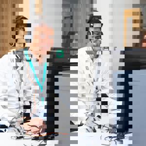 CA Staff Member Sat At Desk With Headset On