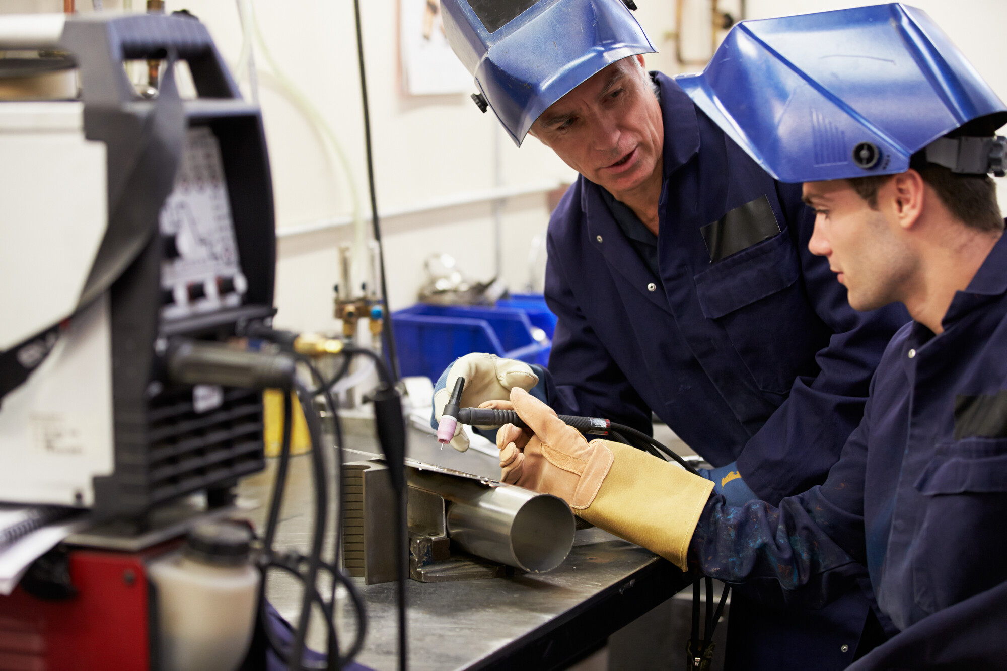 Engineer Teaching Apprentice To Use Welding Machine