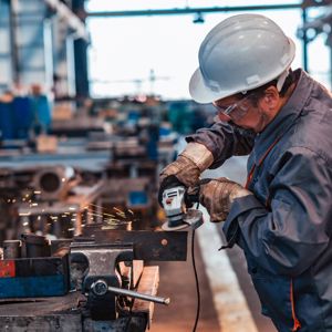 Skilled Industrial Worker Grinding Metal Part