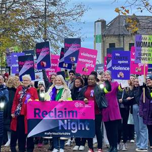 Women at Reclaim the Night march holding banners and placards about violence against women and girls